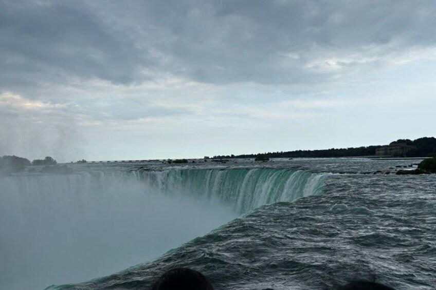 A large waterfall, a body of water, and a distant shoreline with buildings. 4
