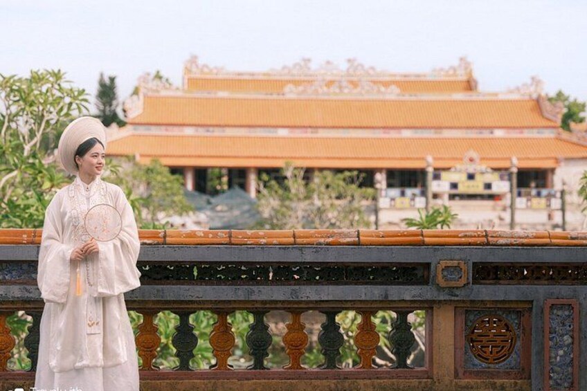 A person in traditional attire standing in front of a historic building with ornate architecture. 5