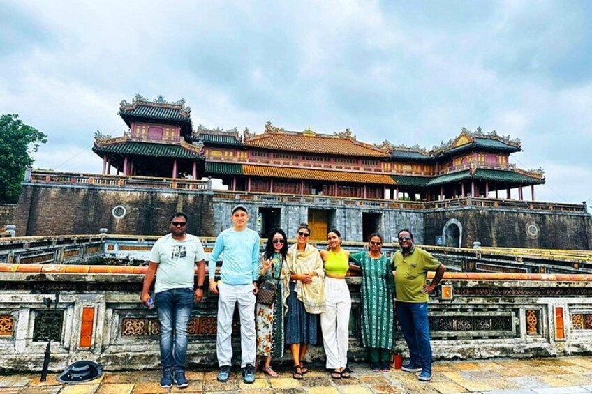 A group of people standing in front of a traditional building with ornate architecture. 2