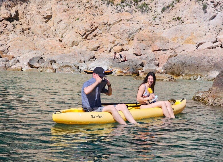 Two people in a yellow inflatable raft on a river with rocky banks. 2
