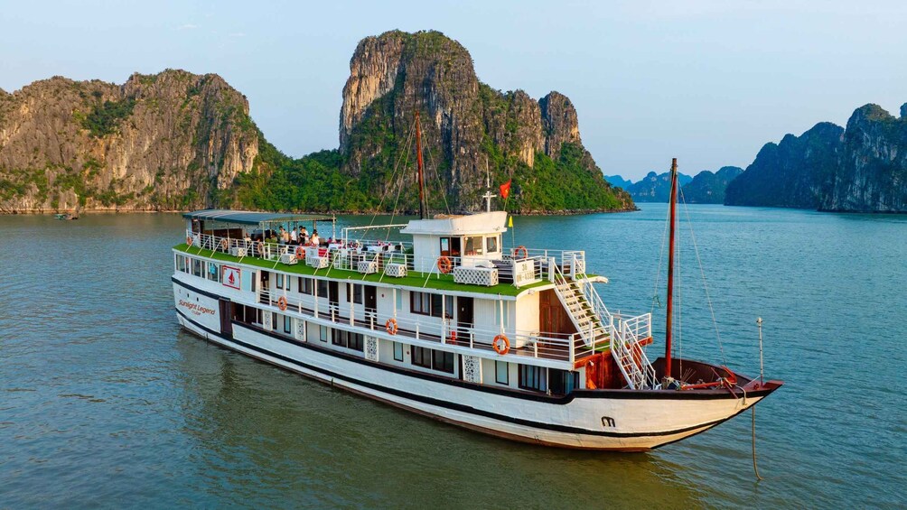 A large river cruise boat with multiple decks and passengers, surrounded by rocky cliffs and water. 2