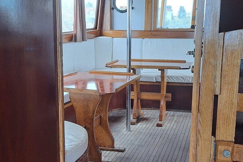 A cabin interior with wooden furniture, a window, and a view of the outside. 4