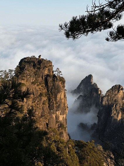 A mountainous landscape with prominent rock formations and dense forest. 1