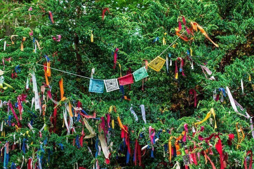 A tree with colorful ribbons and a small flag. 3