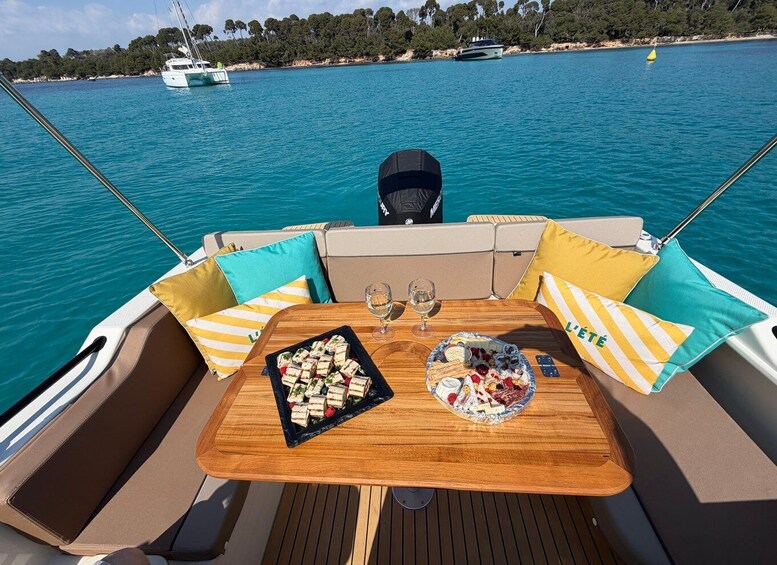 A boat's deck with a table set for two, featuring a dessert and wine glasses. 1