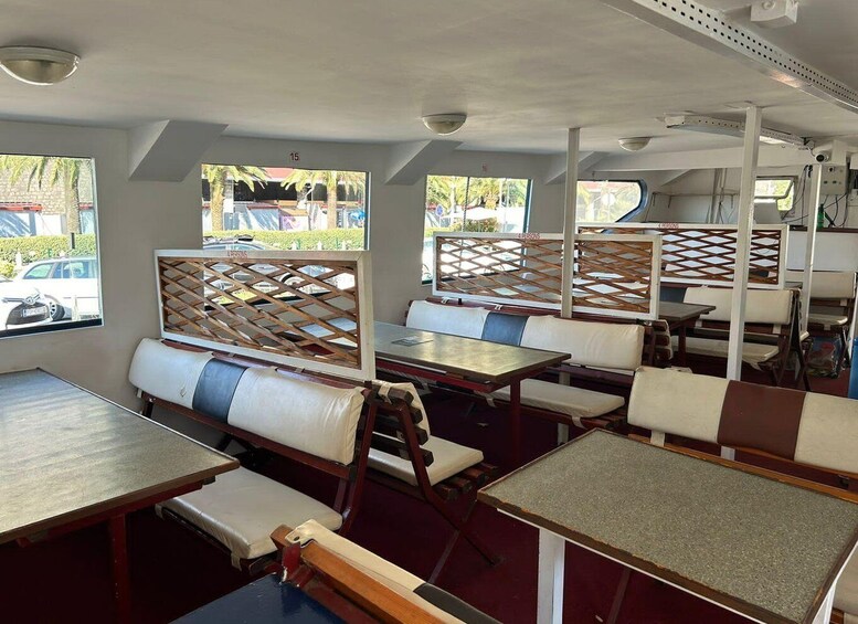 A restaurant with outdoor seating, tables, and a view of parked cars and buildings. 5
