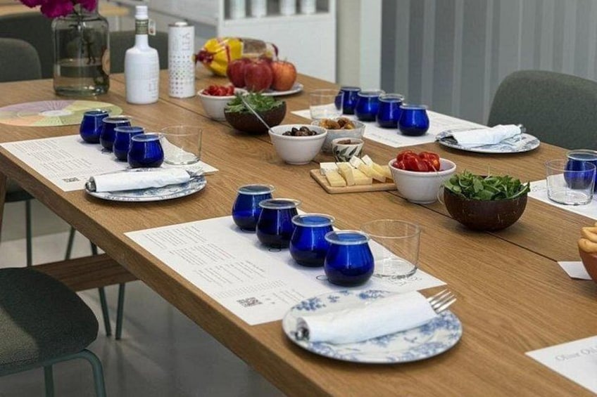 A wooden table set with blue cups, plates, and bowls of food. 4