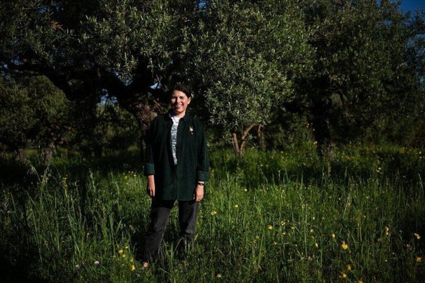 A person standing in a grassy field with trees in the background. 2