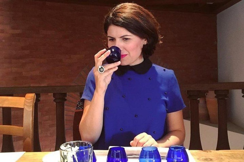A person seated at a table with blue glasses and a dark blue shirt. 3