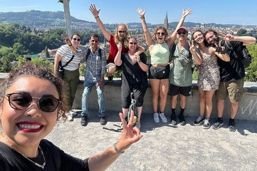 A group of people posing on a ledge with a cityscape in the background. 3