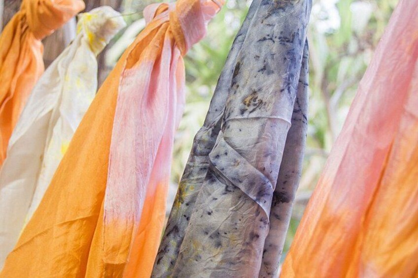 Colorful fabric strips tied to a structure, possibly for drying or display. 3