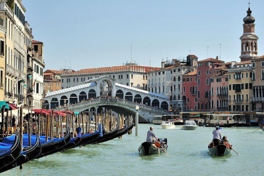 Un canal bordé de gondoles, un pont et des bâtiments historiques à Venise. 1