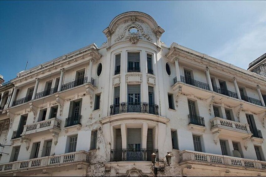 A historic building with classical architecture, featuring a central dome and symmetrical balconies. 1