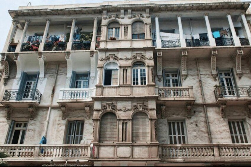 A multi-story building with ornate balconies and arched windows. 4