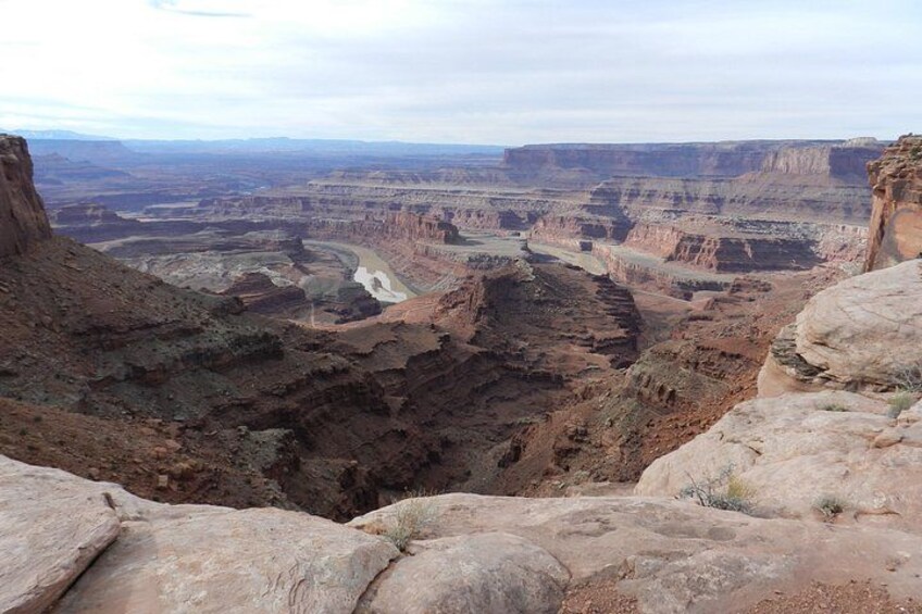 A canyon landscape with layered rock formations and a river. 3