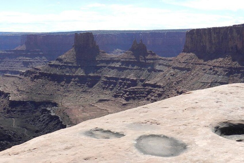 A canyon with layered rock formations and a flat-topped mesa. 2