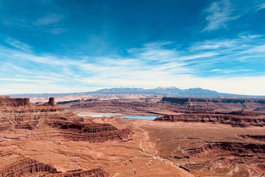 A vast canyon landscape with layered rock formations and a river. 1