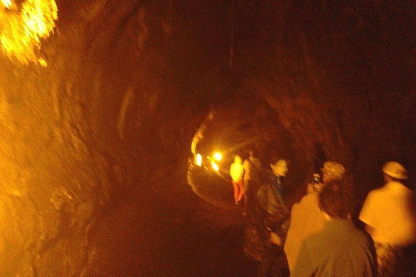 En grupp människor i en mörk grotta med en rund öppning. 4