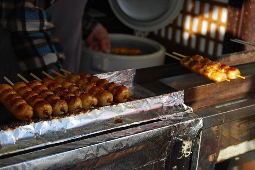 Skewered food items being grilled on a metal surface. 5