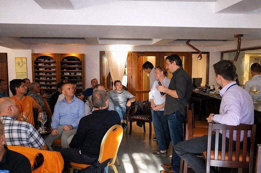 A group of people in a restaurant with wooden furniture and a wine rack in the background. 2