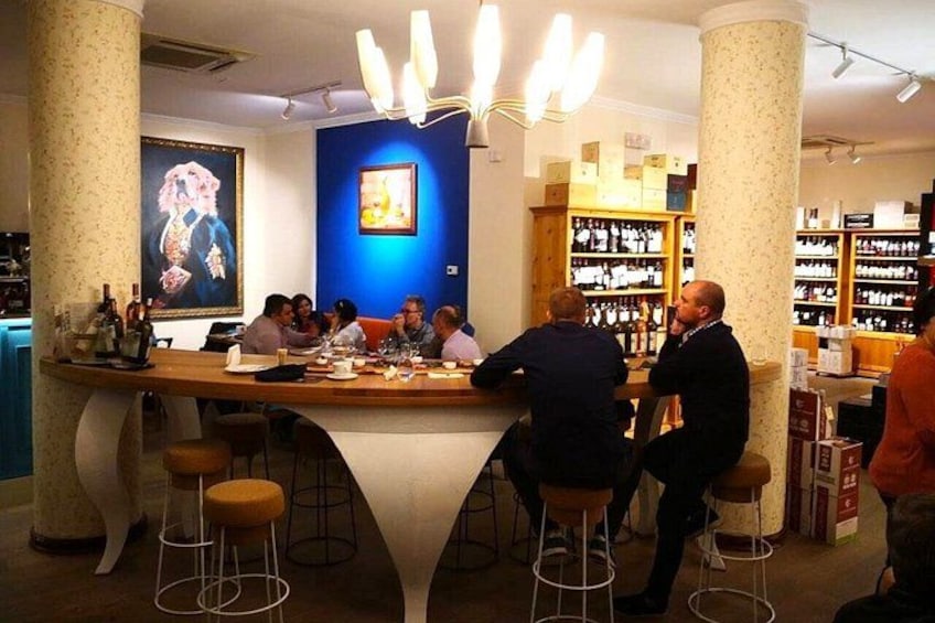 Un bar con clienti seduti ai tavoli, un bancone e scaffali pieni di bottiglie. 4