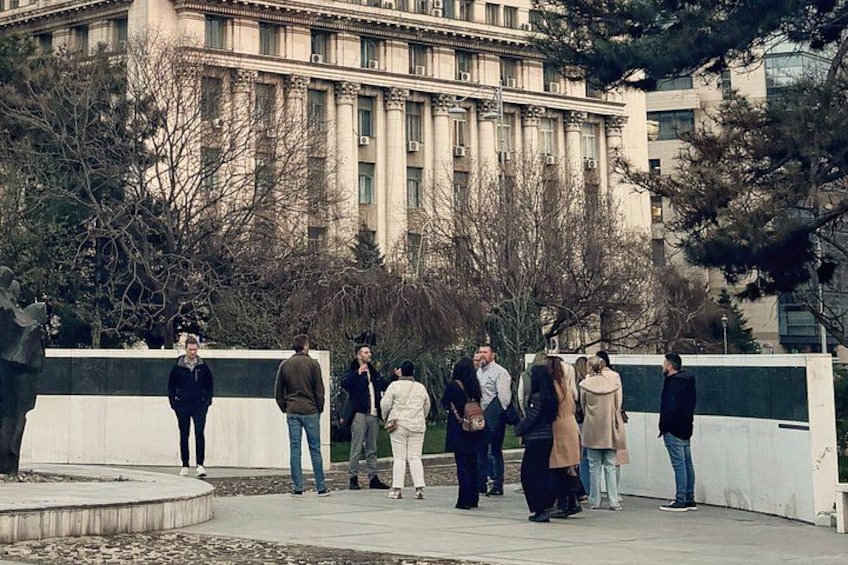 Un gruppo di persone in un parco, con un grande edificio sullo sfondo. 2