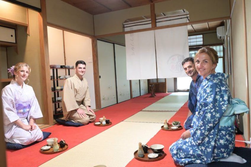 Una habitación japonesa tradicional con suelo de tatami, un felpudo rojo y una disposición para ceremonia del té. 2
