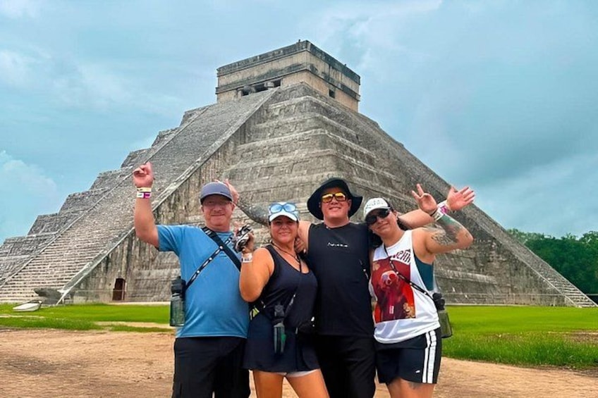 A pyramid with tourists posing in front of it. 1