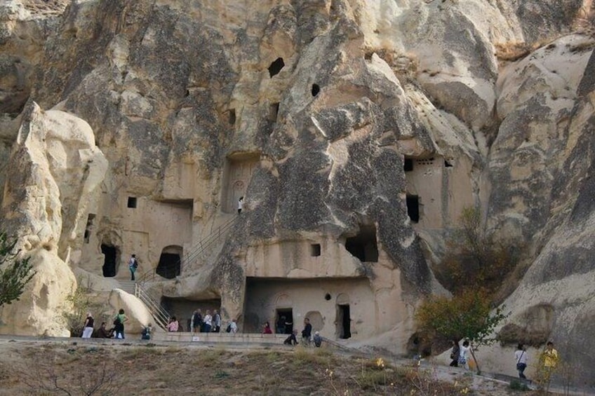 A rock-cut monastery with multiple cave dwellings and a staircase leading to the entrance. 2
