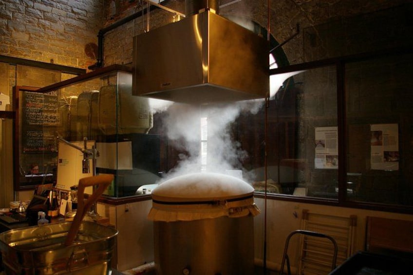 A steamer with steam rising, a brick wall, and a window with papers on it. 3