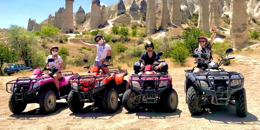 Four people on ATVs in a desert landscape with distinctive rock formations. 3