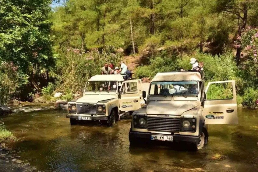 Two safari vehicles on a river surrounded by dense forest. 4