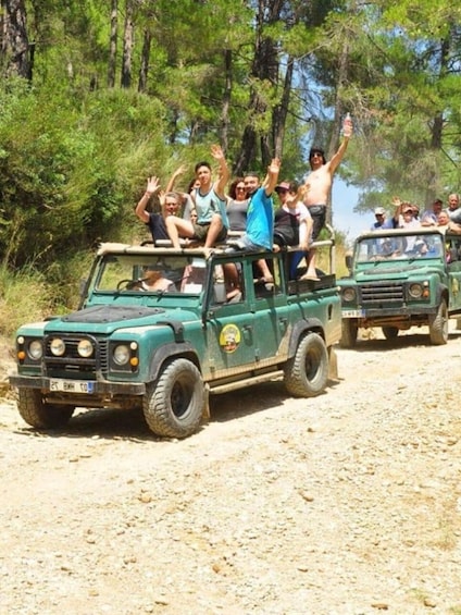 A group of people on a green off-road vehicle in a forested area. 5