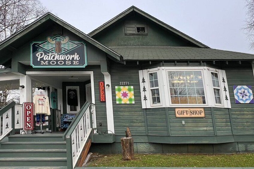 A building with a sign reading 'The Patchwork Moose Gift Shop.' 3