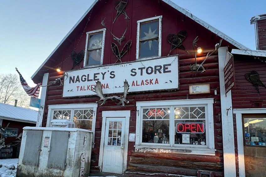 A red wooden building with a sign that reads 'Nagle's Store' and 'Talks, Alaska'. 2