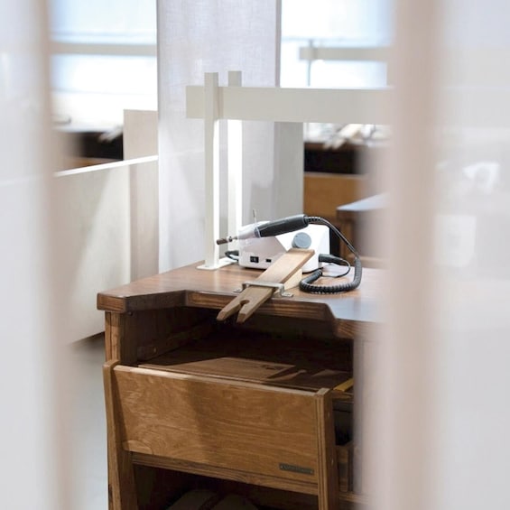 A wooden desk with a laptop, a lamp, and a coiled cable. 1