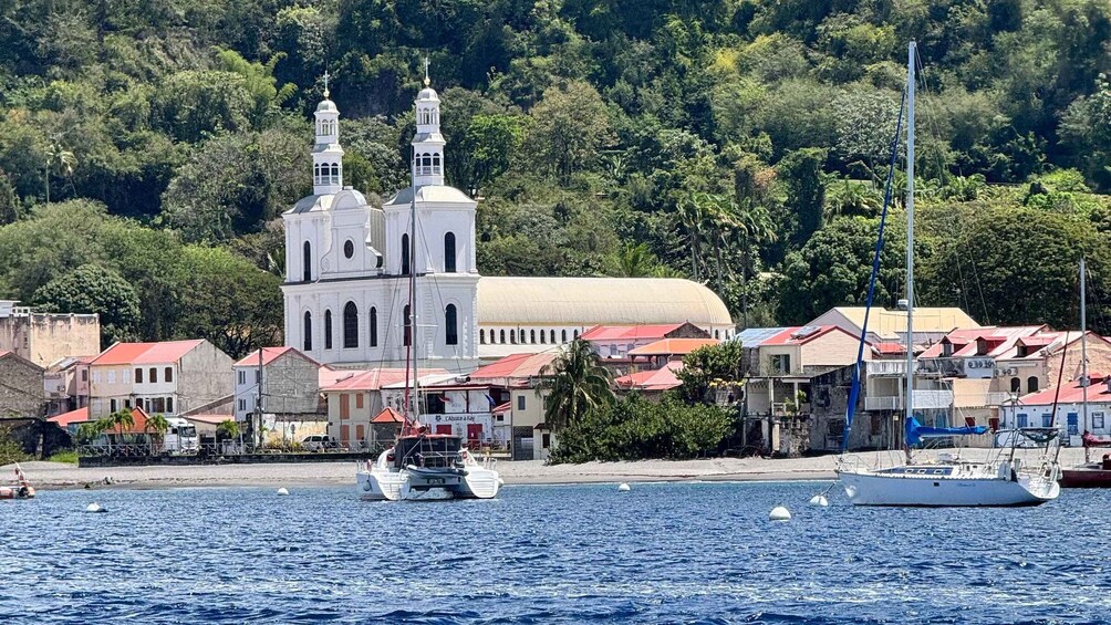 A coastal town with a prominent church, boats, and a hilly backdrop. 2