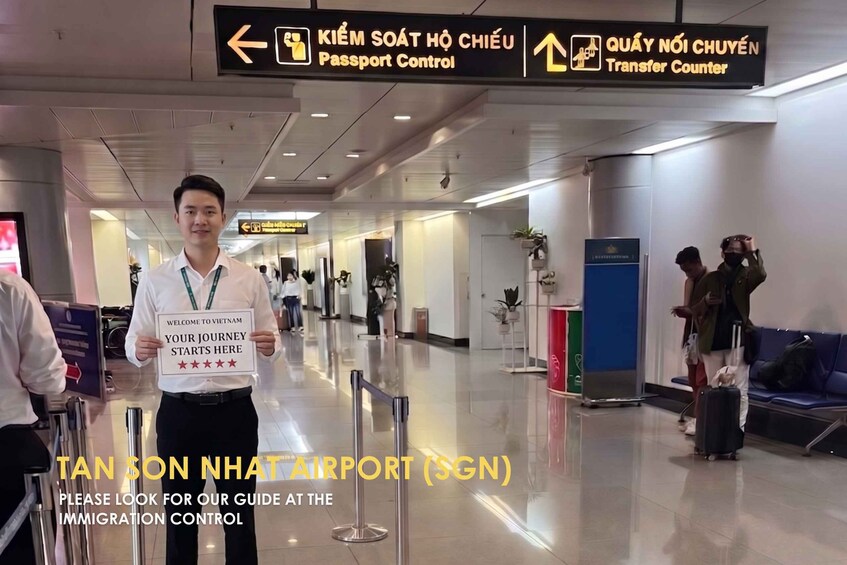 A man holding a sign at Tan Son Nhut Airport (SGN) with a guide at the immigration control. 2