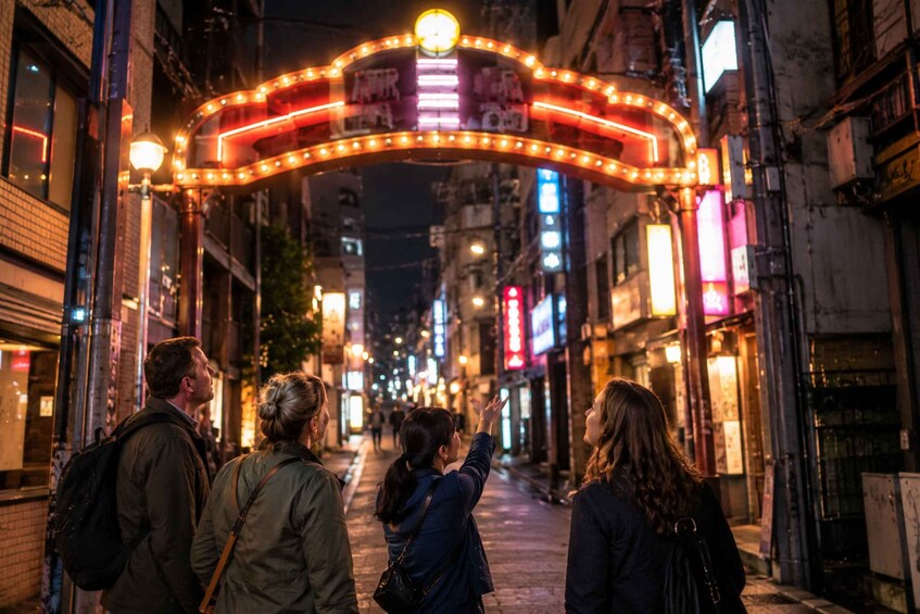 A nighttime street scene with illuminated neon signs and a marquee arch. 4