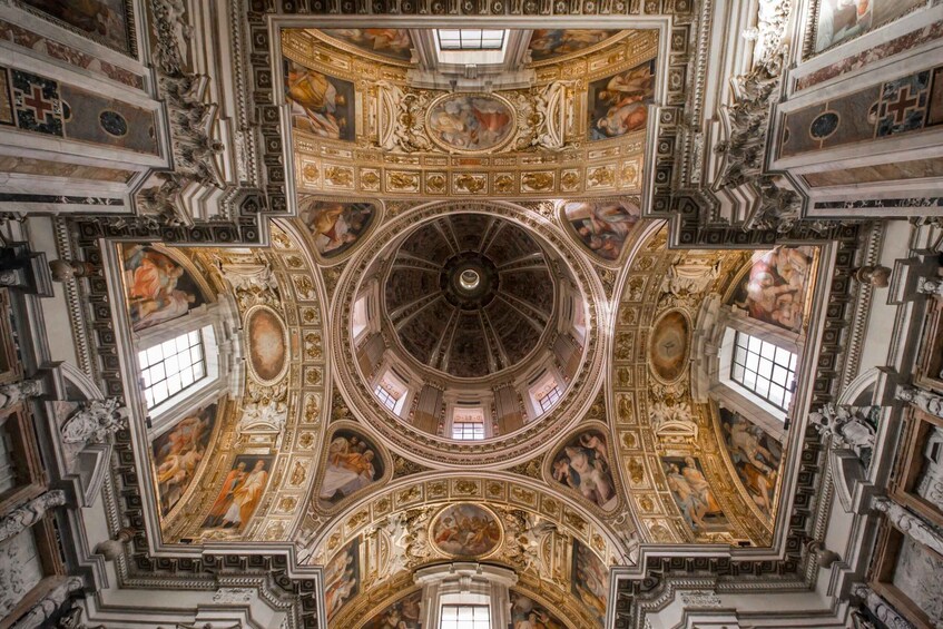 A grand, ornately decorated ceiling with intricate frescoes and architectural details. 2