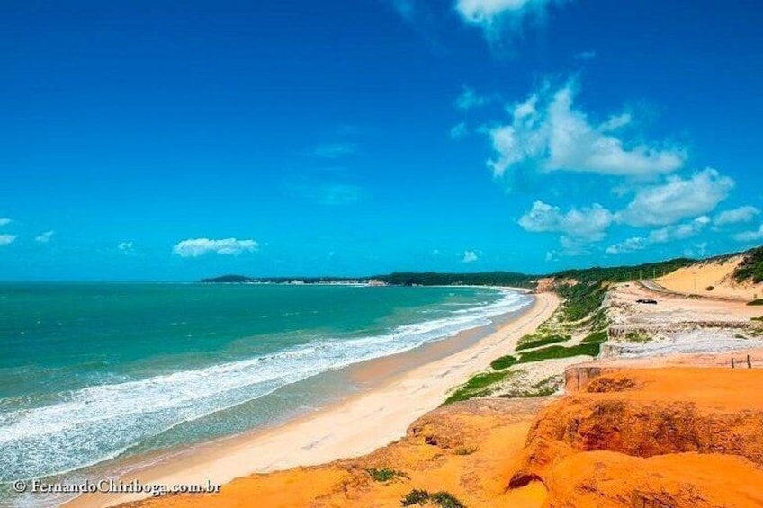 Una spiaggia con acqua cristallina, una riva sabbiosa e vegetazione verde. 4