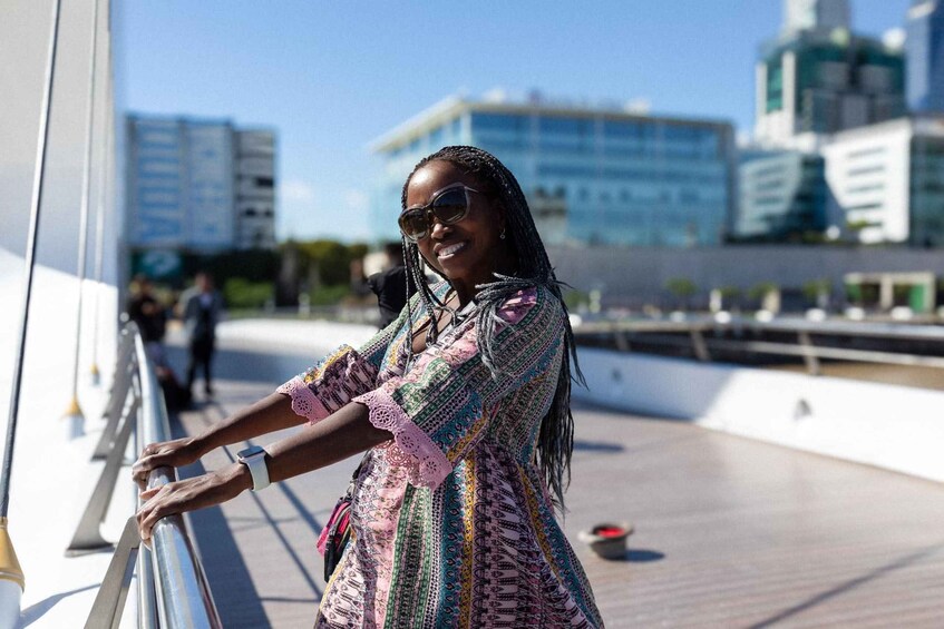 A person standing on a deck with a cityscape in the background. 1