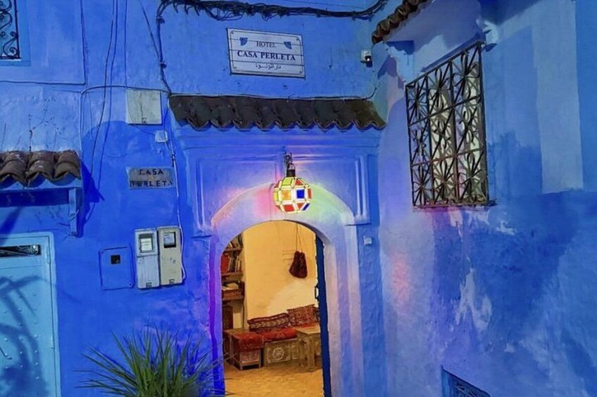 Een gebouw met blauwe muren en een bord waarop 'Hotel Casa Perletta' staat. 2