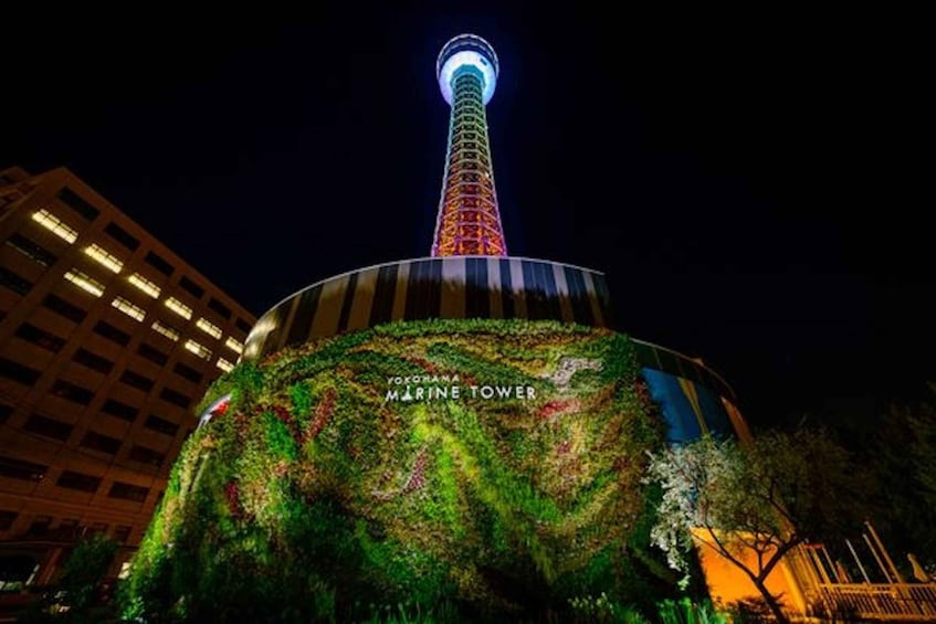 Yokohama Marine Tower at night with illuminated top and a green rooftop garden. 1