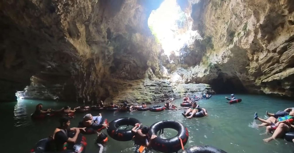 People floating in a cave with water tubes. 3