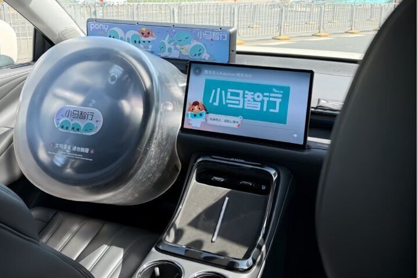 Een auto-interieur met een digitaal display, een pedaal en een bekerhouder. 5