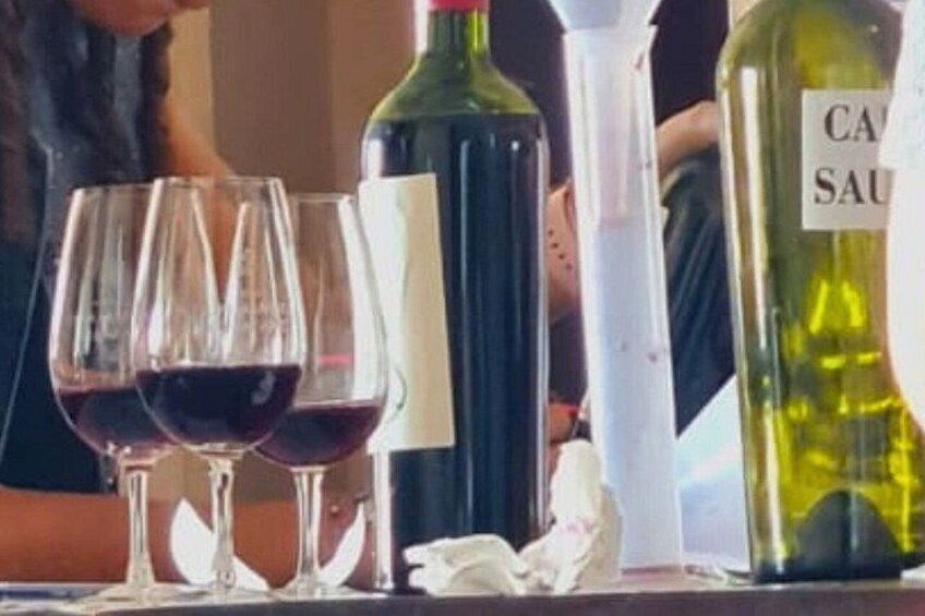 Wine glasses, a green wine bottle, and a white bottle with a label. 4