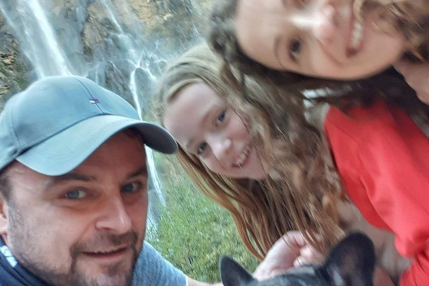 Une personne portant une casquette, une personne vêtue d’un haut rouge et un chien. 5