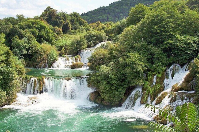 A multi-tiered waterfall surrounded by lush greenery. 5