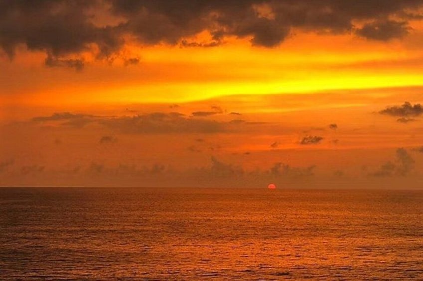 Atardecer sobre el océano con nubes y el sol visible. 2